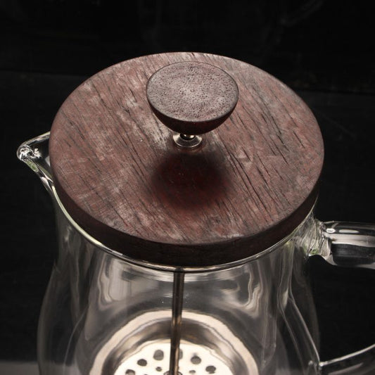 Close-up of natural rosewood lid on a glass French press, showcasing rich wood grain. #Rosewood #CoffeeStyle