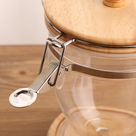 Glass jar with wooden lid and metal clasp on a wooden surface
