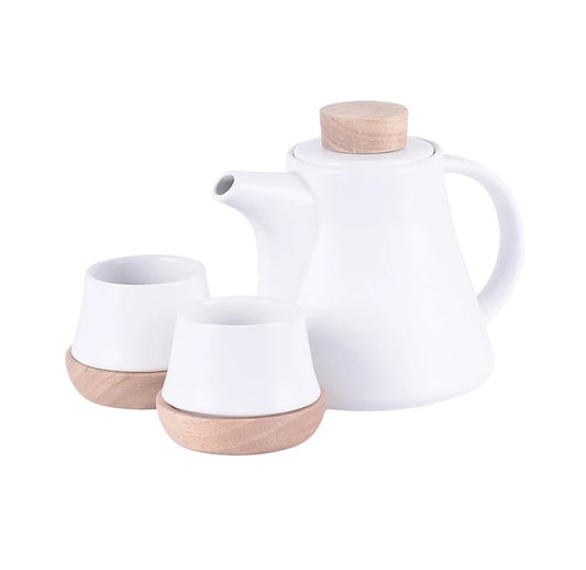 White ceramic teapot and two cups with wooden bases