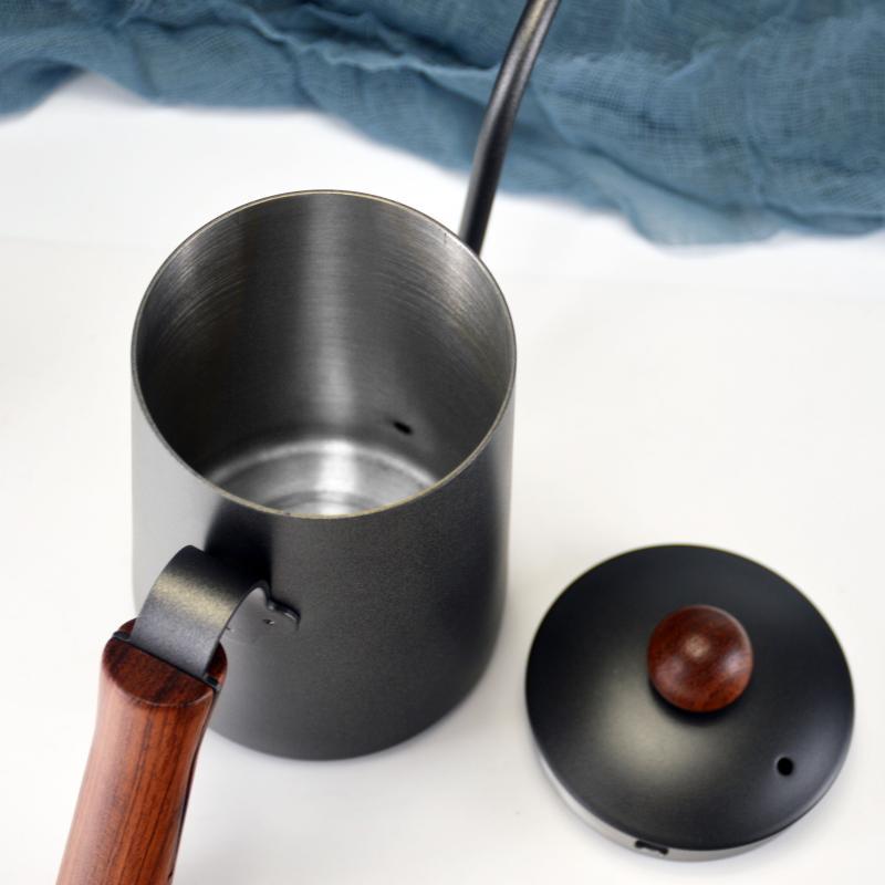 dark grey 650ml pour over coffee kettle with wooden handle and lid on white surface with plant