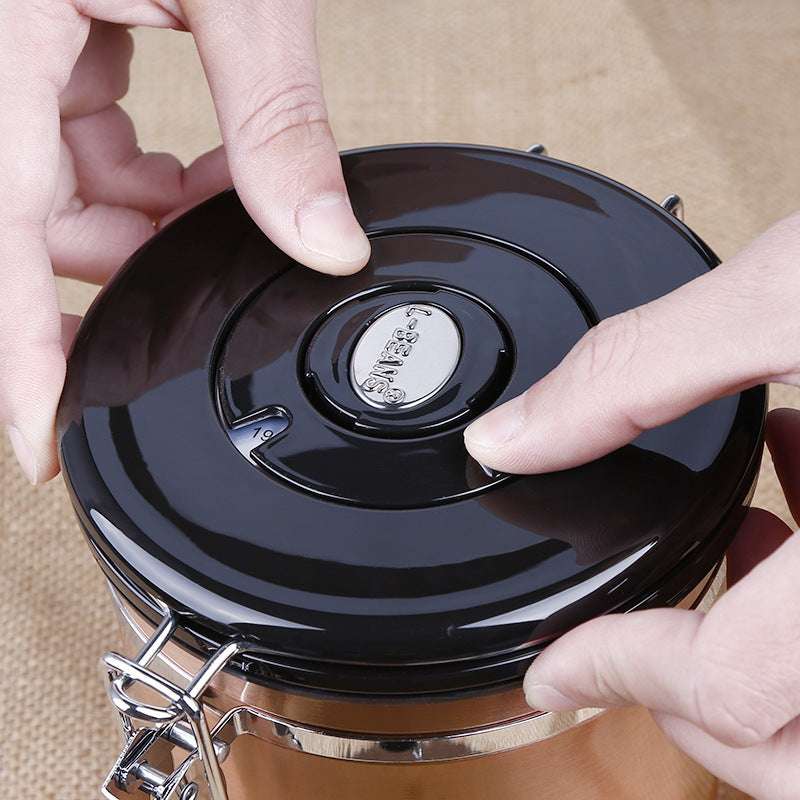 A close-up shot of hands adjusting the date tracker on the black lid of a coffee canister. Shop NOW