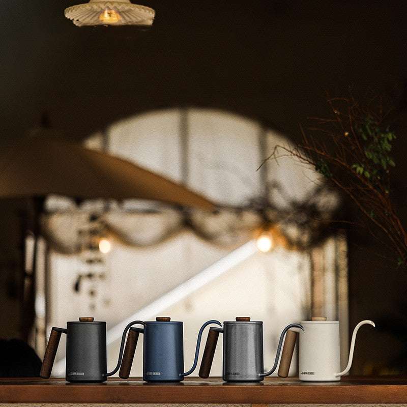 Planet gooseneck kettles in black, blue, gray, and white with wood handles for home coffee brewing.