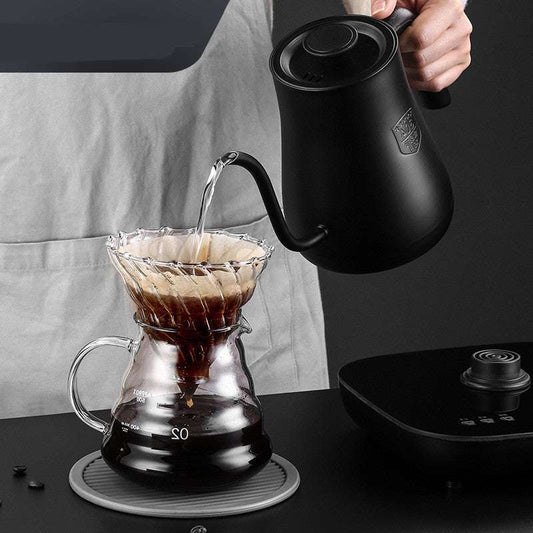 Pouring water from black gooseneck kettle into a glass coffee dripper for perfect pour-over brewing.
