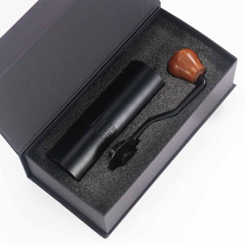 Black manual coffee grinder in gift box – stylish home coffee equipment.