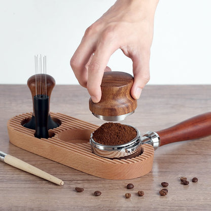 A hand tamping coffee grounds in a portafilter while it rests securely on the wooden tamping station, illustrating the stability and convenience of the product during use. Shop now