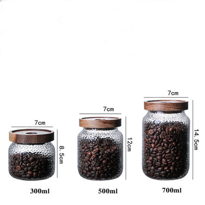 Sizing chart for three glass coffee canisters: 300ml (8.5cm), 500ml (12cm), and 700ml (14.5cm) with wood lids.