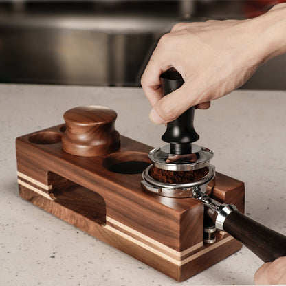  A shot of a person using the wooden coffee tamping station to press down coffee grounds, demonstrating its stability and ease of use. Shop now