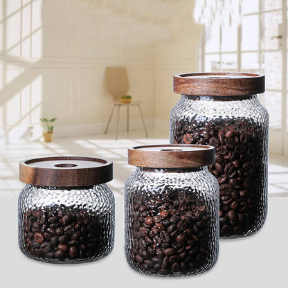  A single 500ml glass canister with a wooden lid, filled with coffee beans, photographed against a white background.