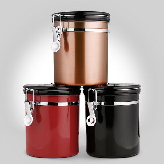 A stack of three stainless steel coffee canisters in bronze, red, and black with airtight clamp lids. Shop now!
