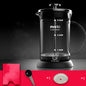 Black coffee maker with measurement markings on a dark background