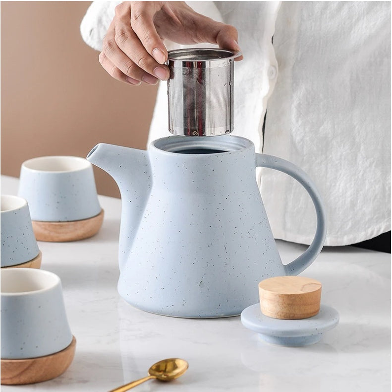 Blue ceramic teapot with wooden lid and tea cups 