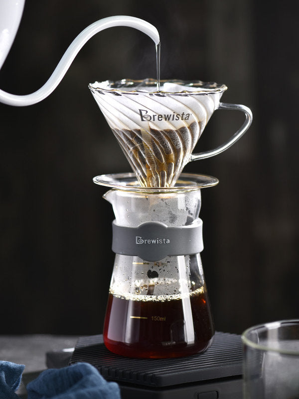 Brewista coffee brewing setup with glass carafe and white pouring device on a dark background Shop now