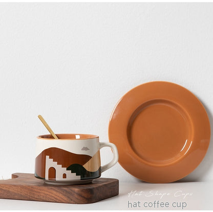 Ceramic mug with geometric design and matching plate on a wooden board against a white background.