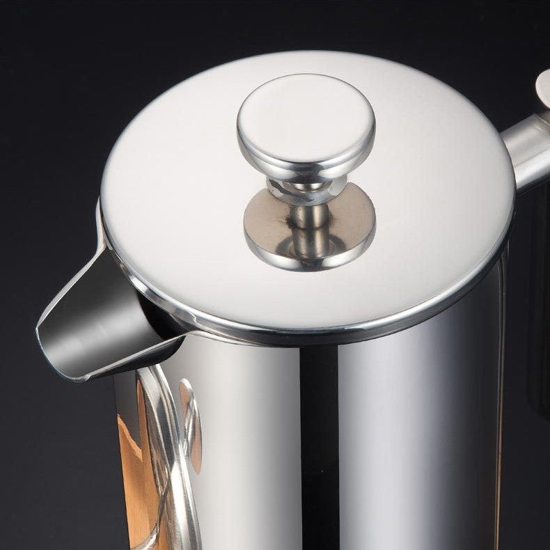 Close-up of a silver French press coffee maker on a black background
