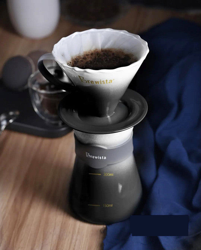 Coffee brewing process using a Brewista pour-over coffee maker on a wooden surface.