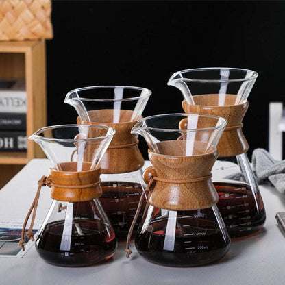 Four different sizes (400ml, 600ml, 800ml, 1000ml) of the glass pour-over coffee maker with wooden collars, lined up on a white table. SHOP NOW! FREE SHIPPING!