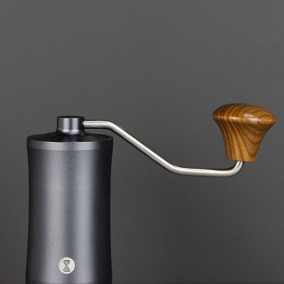 Hand coffee grinder with wooden handle on a dark background