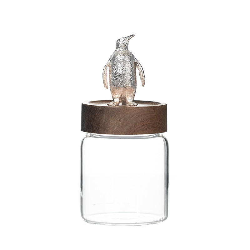 Glass jar with wooden lid and penguin decoration