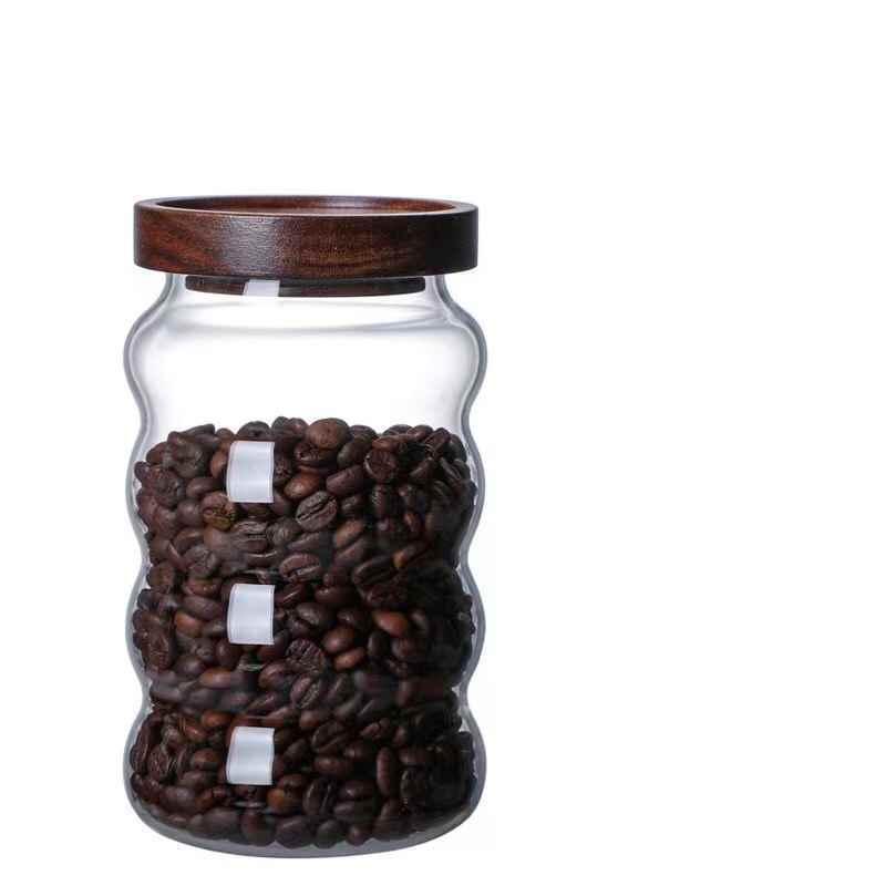 Glass jar with wooden lid filled with coffee beans Shop now!