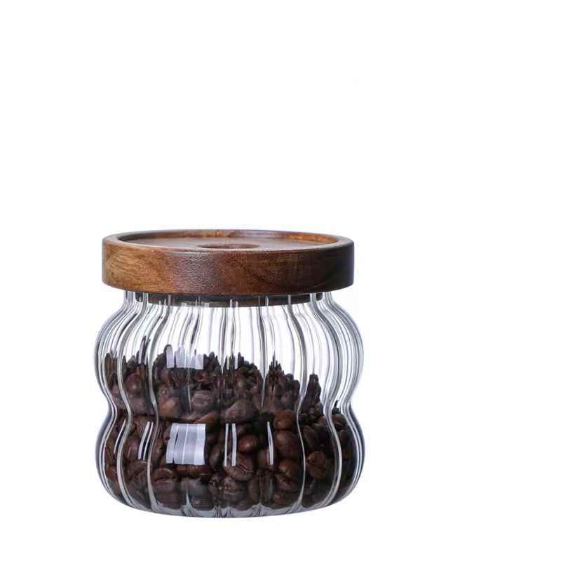 Glass jar with wooden lid filled with coffee beans on a Shop now