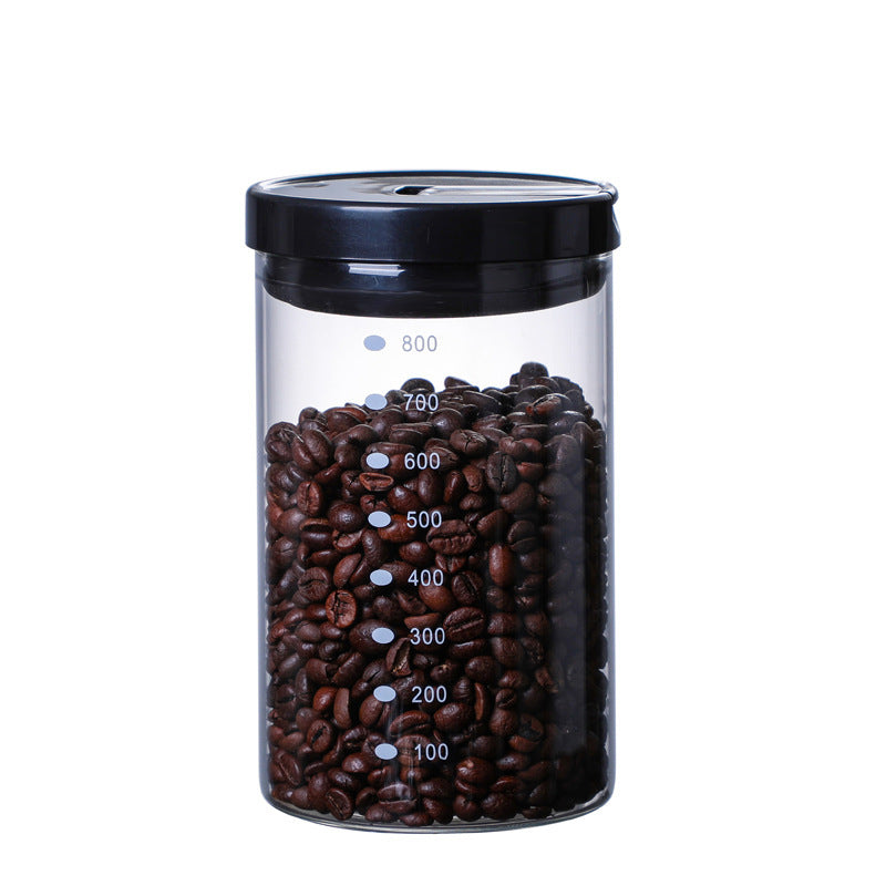 Hand holding a 600ml airtight glass canister for coffee beans, showing its measurements and sleek design. FREE SHIPPING






















