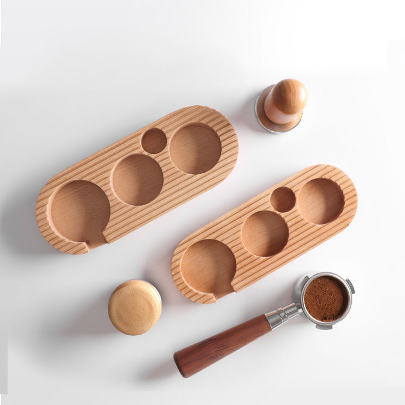 Overhead view of two wooden coffee tamping stations and various coffee accessories like tampers and portafilters, showcasing the product's versatility and elegant look. shop now