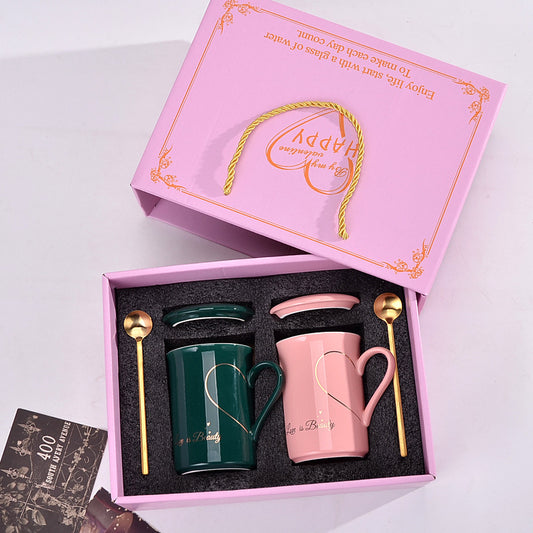 Pink and green mugs with heart designs in a decorative box, featuring 'Happy' text.