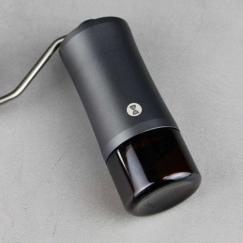 Coffee grinder Black cylindrical device with a logo on a gray surface
