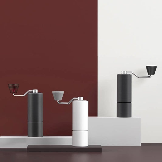 Manual coffee grinders in black, white, and dark grey. Stylish and portable for any coffee lover. #CoffeeTools #GiftForCoffeeLover