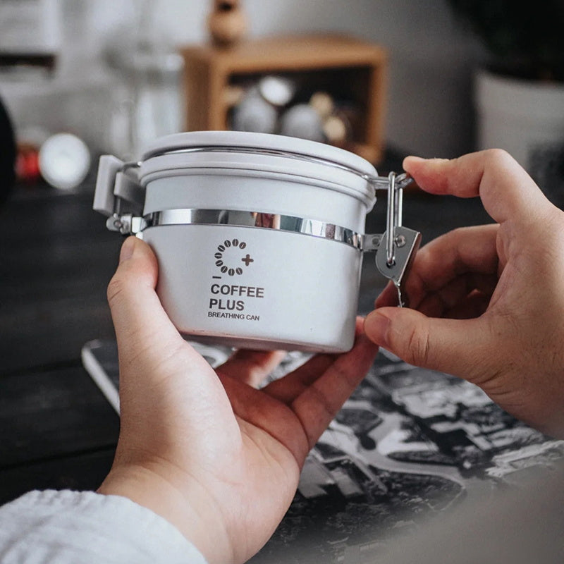 Product shot of the white Coffee Plus Breathing Canister, a stylish and airtight container with a one-way valve for storing coffee beans.