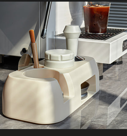 White coffee grinder on a kitchen counter with a coffee machine in the background