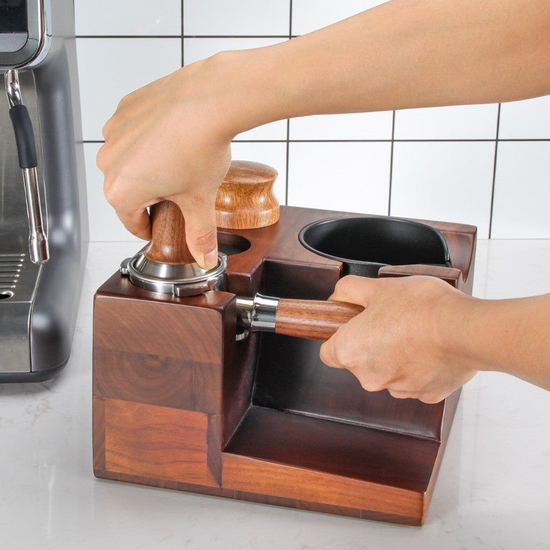 Wooden coffee tamping device with hands using it on a coffee grinder. Shop now