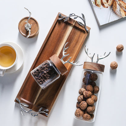 Wooden tray with glass containers holding coffee beans and walnuts