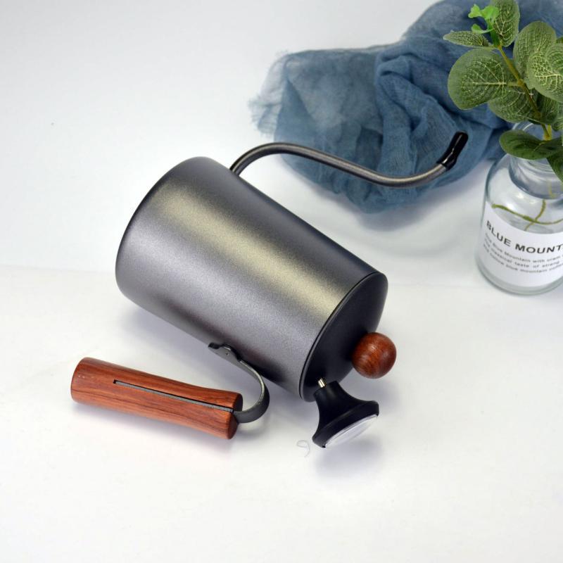Metal coffee grinder with wooden handles on a white surface
