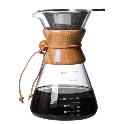 Close-up of a glass pour-over coffee maker with a wooden collar and stainless steel reusable filter, filled with dark coffee. The carafe shows measurements. FREE SHIPPING SHOP NOW